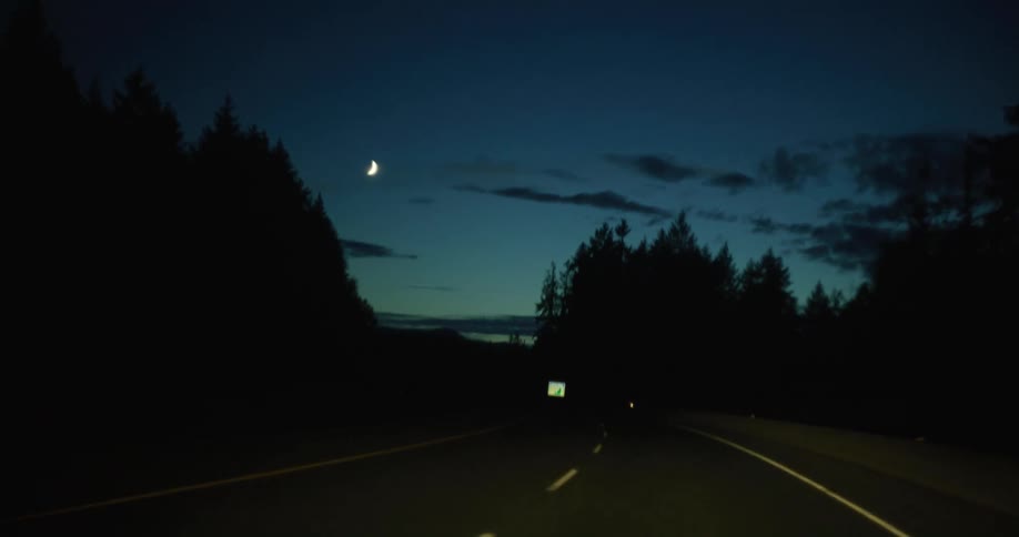 Cars are driving down aroad at night