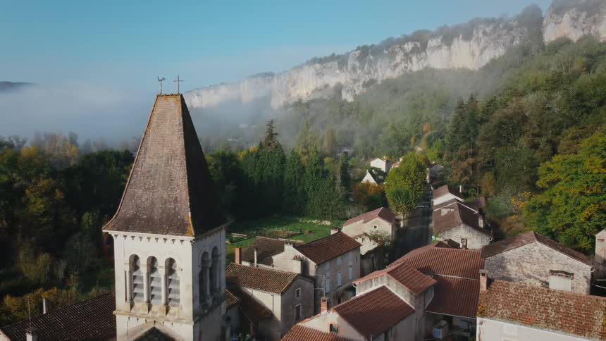 An aerial view of a church nestled amongst buildings in a small town