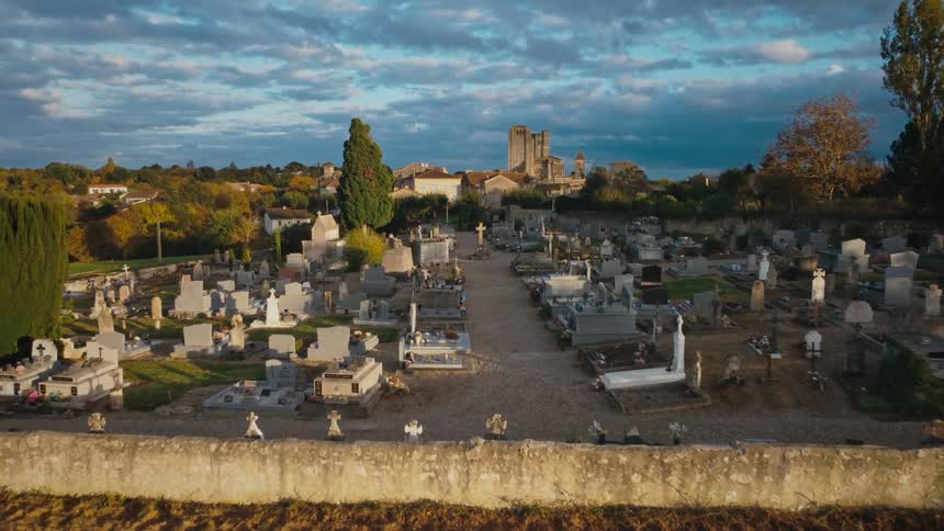 A walled cemetery on the outskirts of a rural town during the day