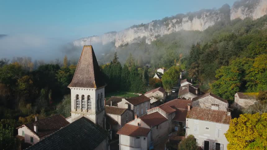 There are trees surrounding the homes alongside mountains in the distance