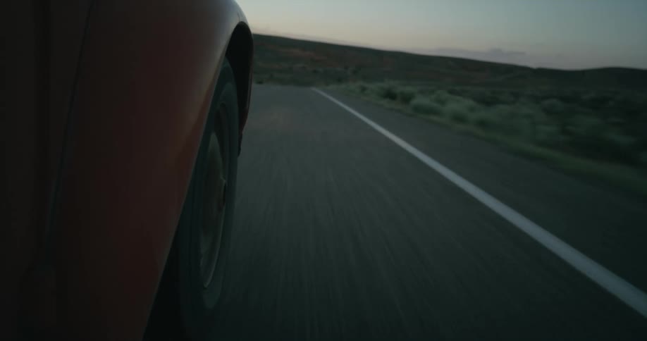 A car is driving on aroad in a rural area