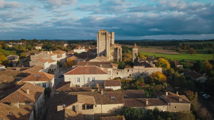 A large church looms over a small town in the countryside during the day