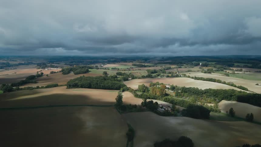 Aerail view of farmlands and rural area under clouds