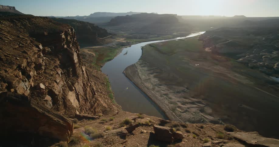 A river running below a cliff in the countryside during the day