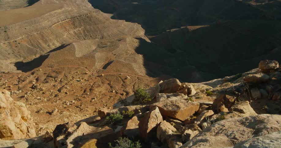 A rock strewn slope beneath a butte in the badlands during the day