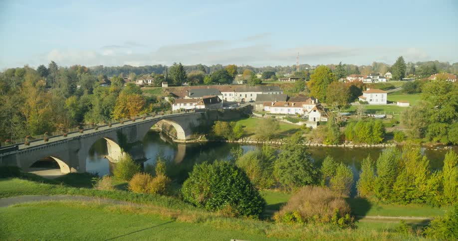 A river running along the outskirts of a town in the countryside during the day