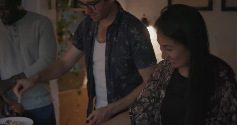 Two men and woman prepare food together