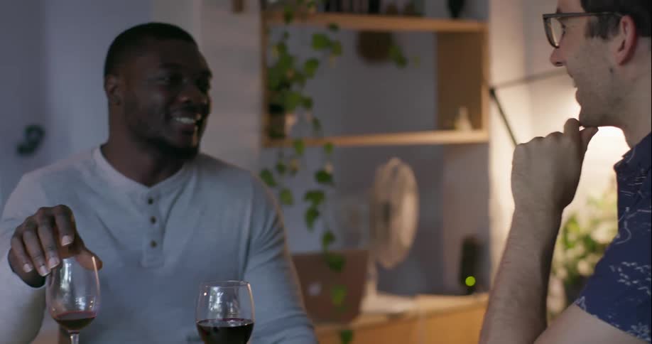 Two men talk at a table in front of food