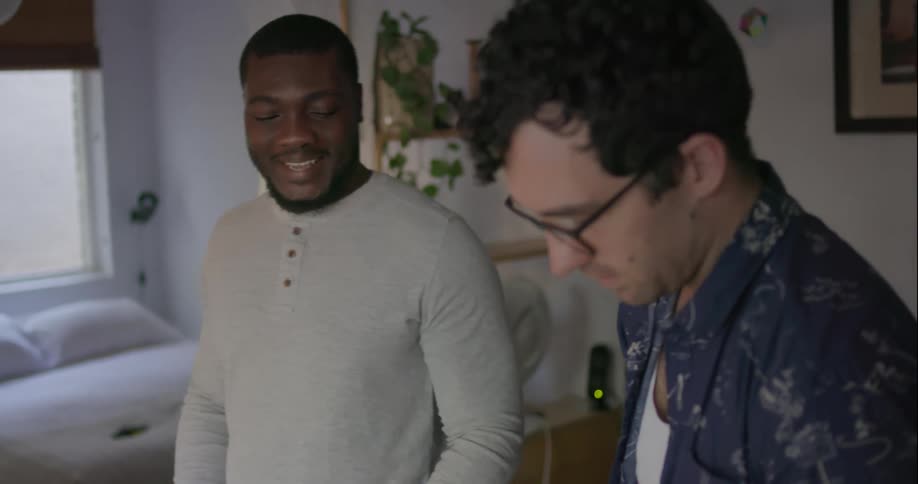 Two men stand at the kitchen counter preparing a taco meal