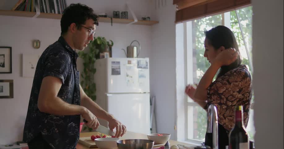 A man and woman prepare food in the kitchen