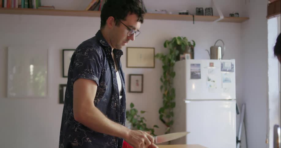 Man and woman chop food on a kitchen counter