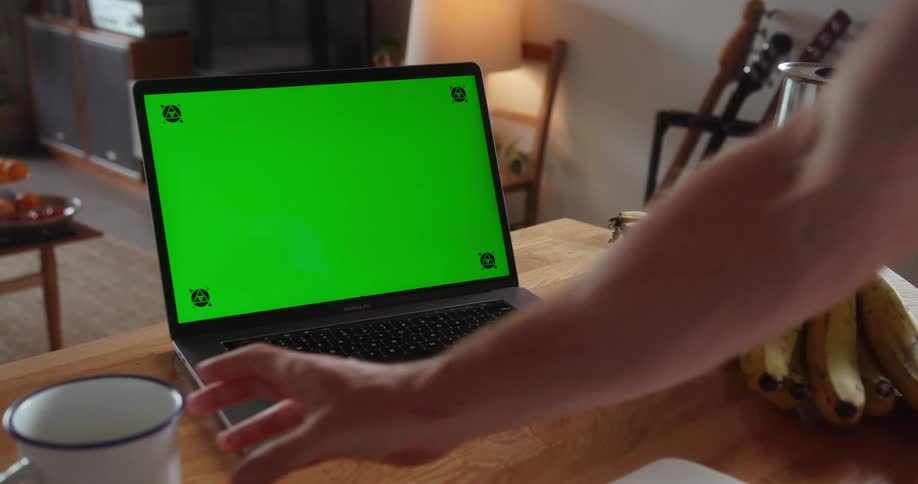 A person using a laptop lifts the mug