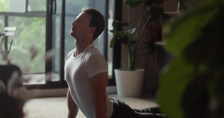 A man does yoga inside a living room