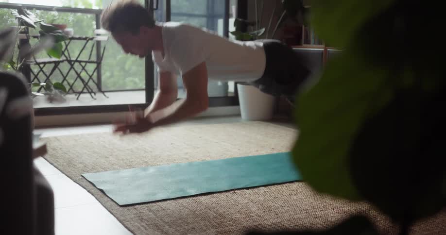 A man does push ups on a yoga mat