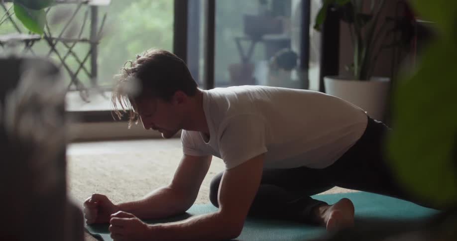 A man is performing yoga at home