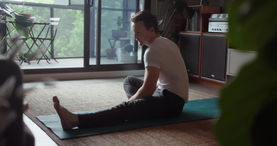 Man stretches on a yoga mat