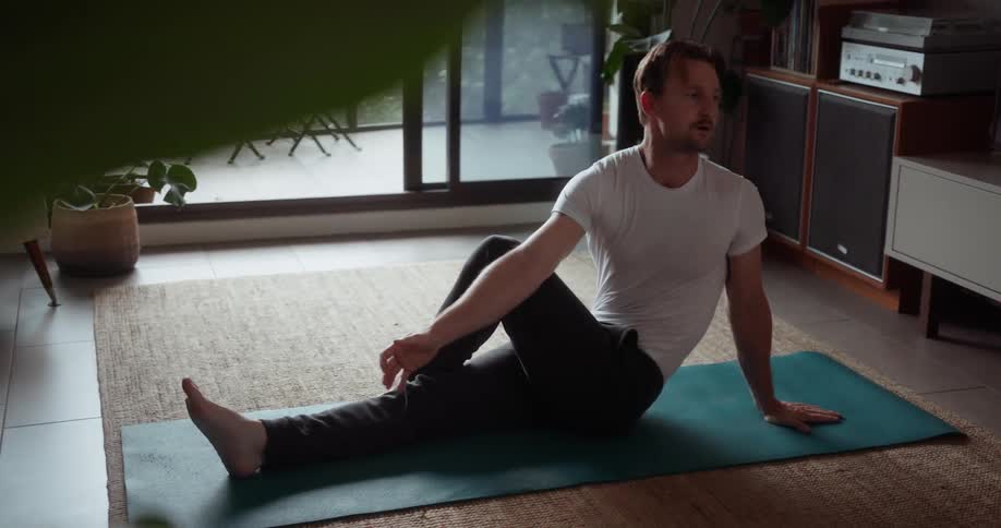 A man stretches on a yoga mat