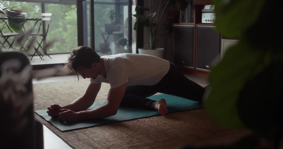 A man stretches on a yoga mat
