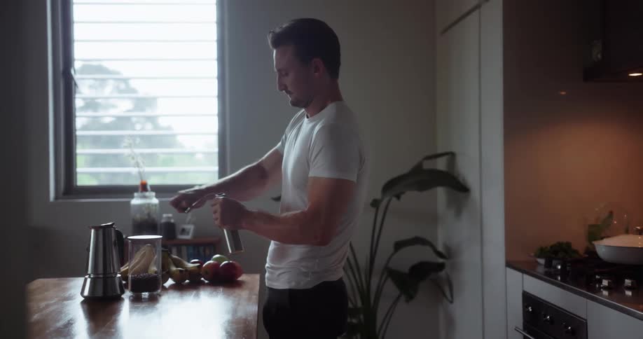 A man winds a piece of kitchen equipment