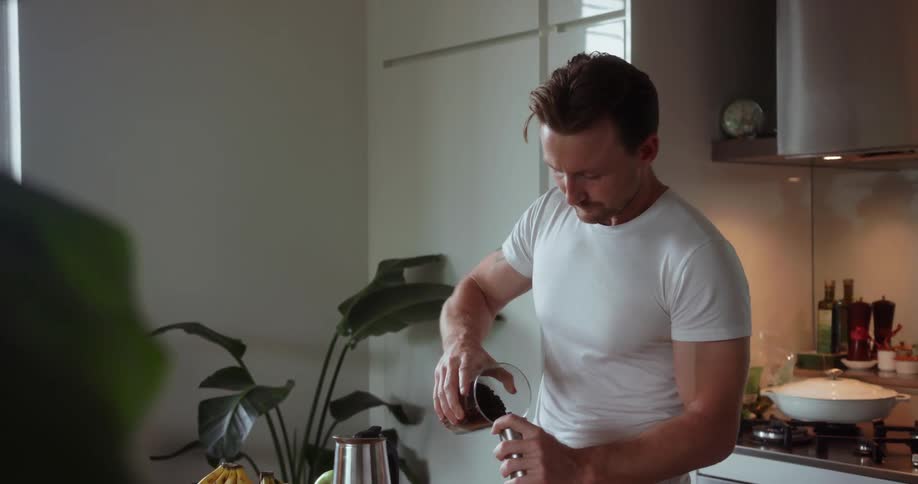 A man smells a canister of coffee beans