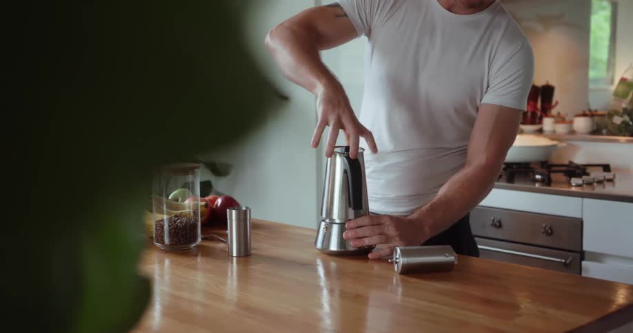 A man twists together a steel kettle