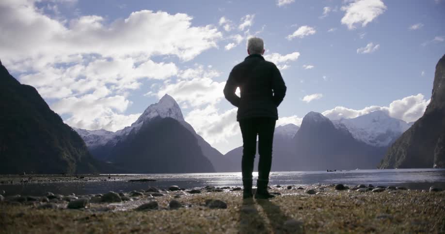 A woman stands by the lake overlooking the great view