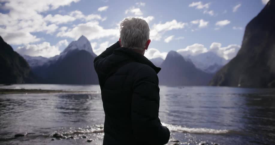 A woman looks out over a mountainside lake