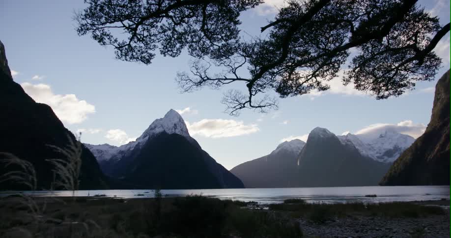 The water is calm near the mountains