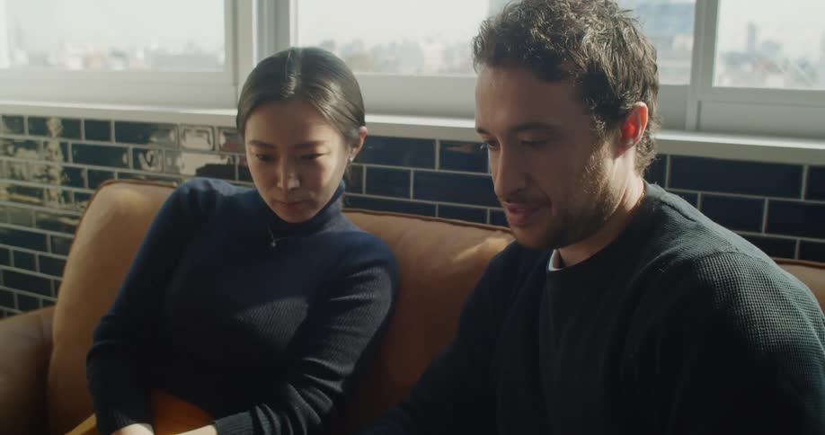Man and woman look at laptop computer and talk