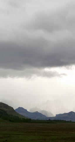 Thick clouds loom of a grassland on a foggy morning