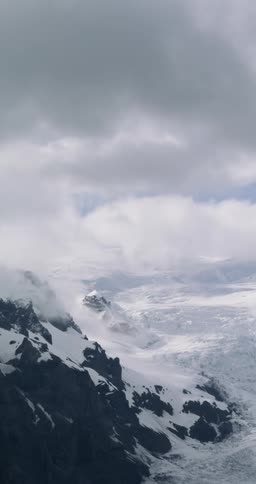 Clouds over a snow covered mountain range