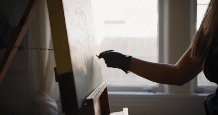 A woman is painting on the canvas
