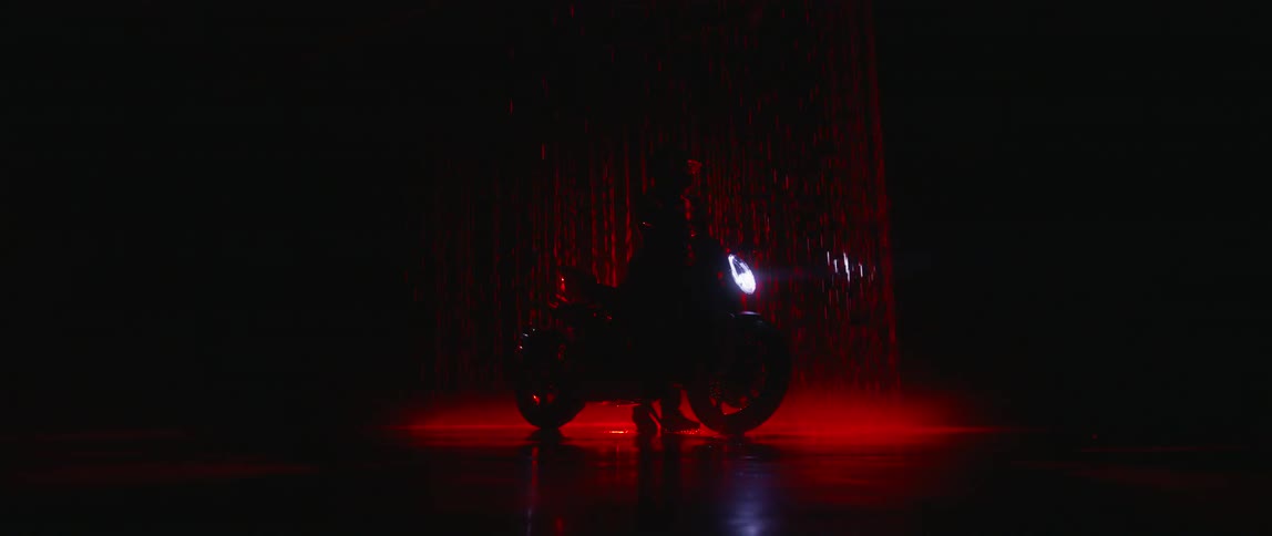 A person straddles a motorcycle on stage