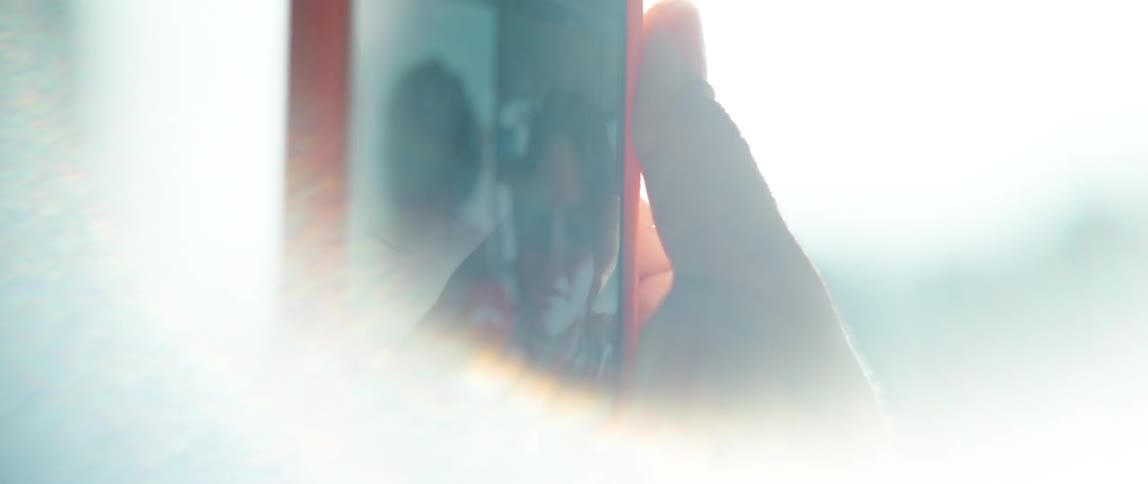 Womans hand holding red smarpthone makes video call