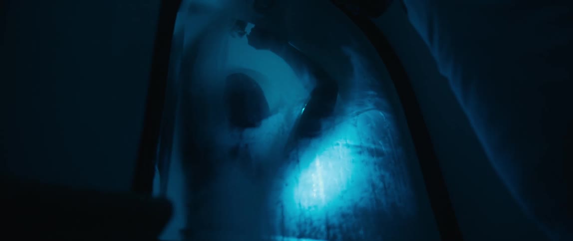 A man is leaning against the shower door