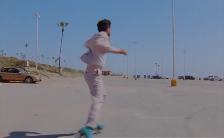 A man dances on roller skates in a parking lot