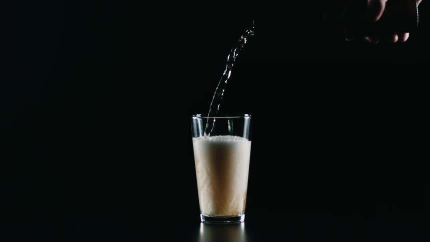 A person pours beer into a glass