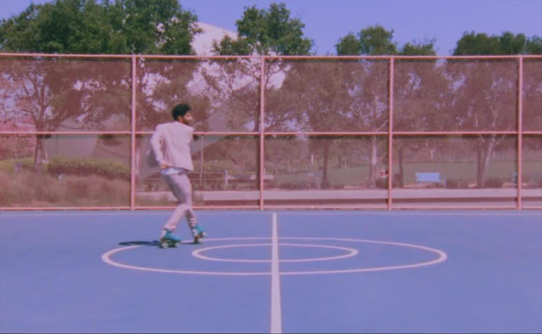 A man dances in roller skates on a tennis court