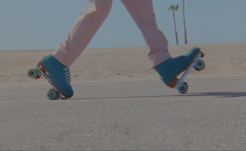 A man dances in roller skates in a parking lot