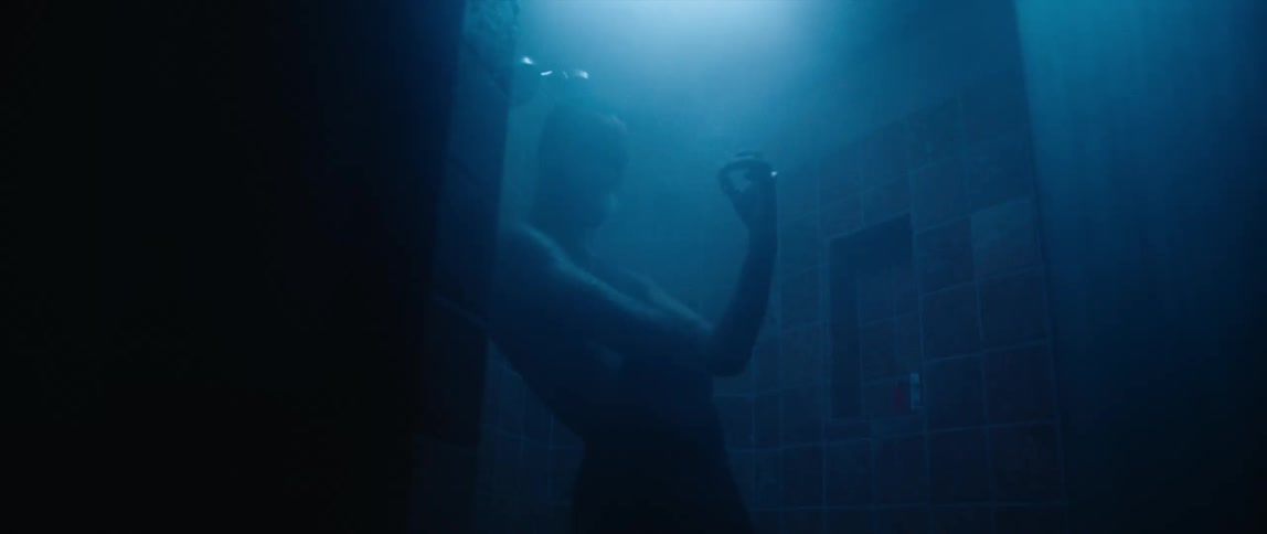 A person is standing in a bathroom with the lights off