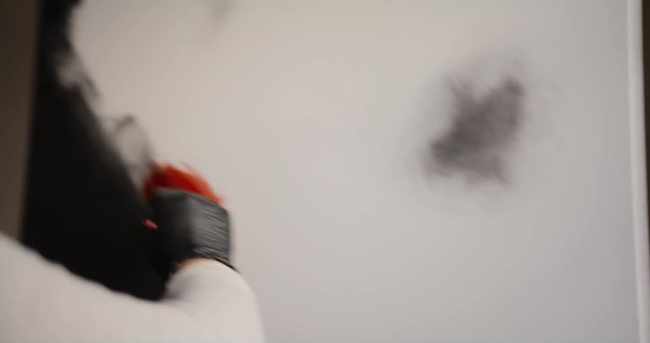 Woman with black gloves paints a picture