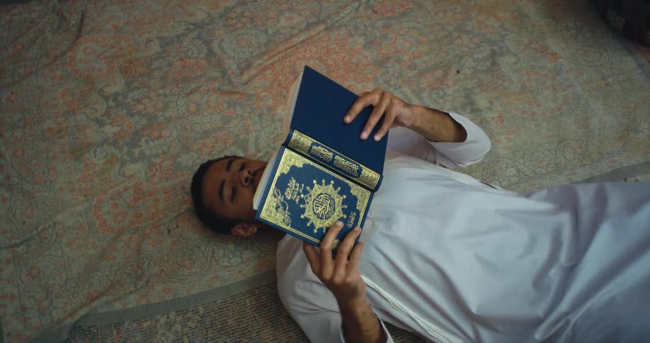 A person is reading a book while laying on the ground
