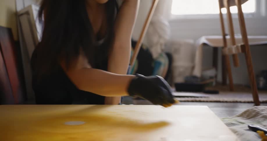 A woman is sponge painting on a canvas