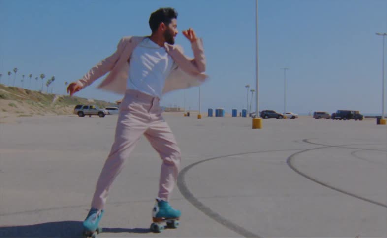 A man is dancing on roller skates in the parking lot