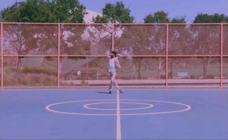 Man on turquois roller skates moves over a hard surface in the court