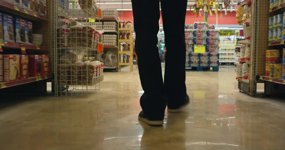 A person walks through an aisle in a grocery store