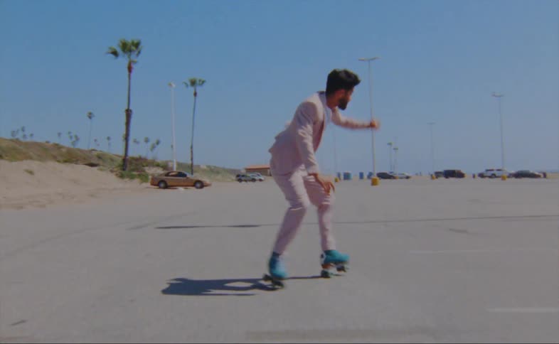 A man on roller skates dances in a parking lot