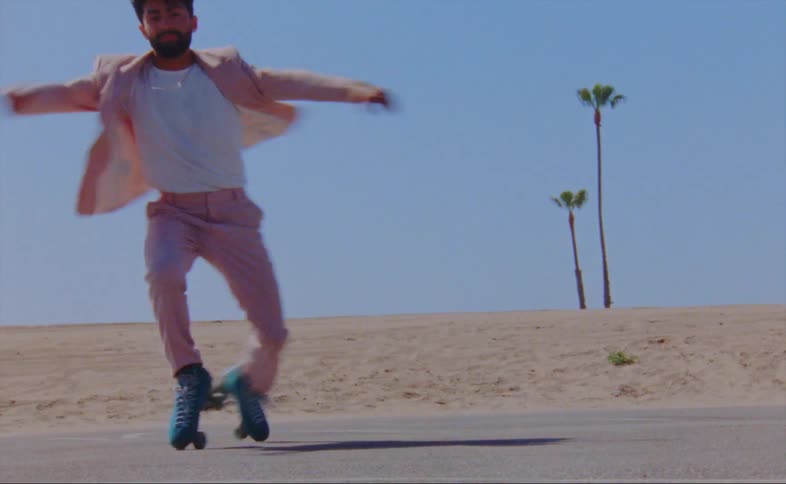 A man spins on roller skates in a parking lot