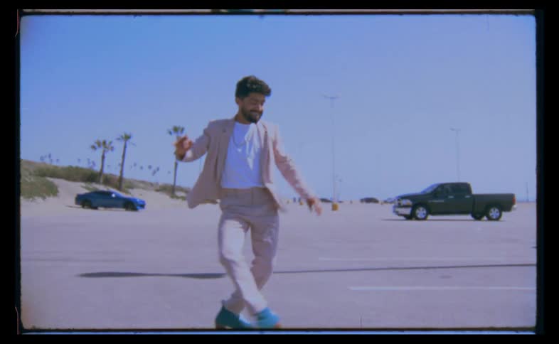 A man is dancing on skates in a parking lot