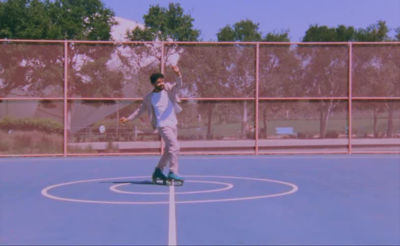 Mandances on roller skates in fenced in sports court at the park